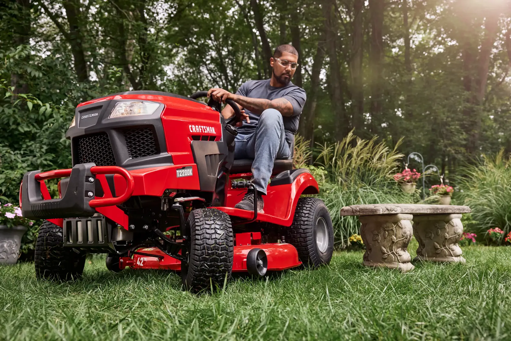 Homeowner mowing a shaded backyard with the CRAFTSMAN T2200K