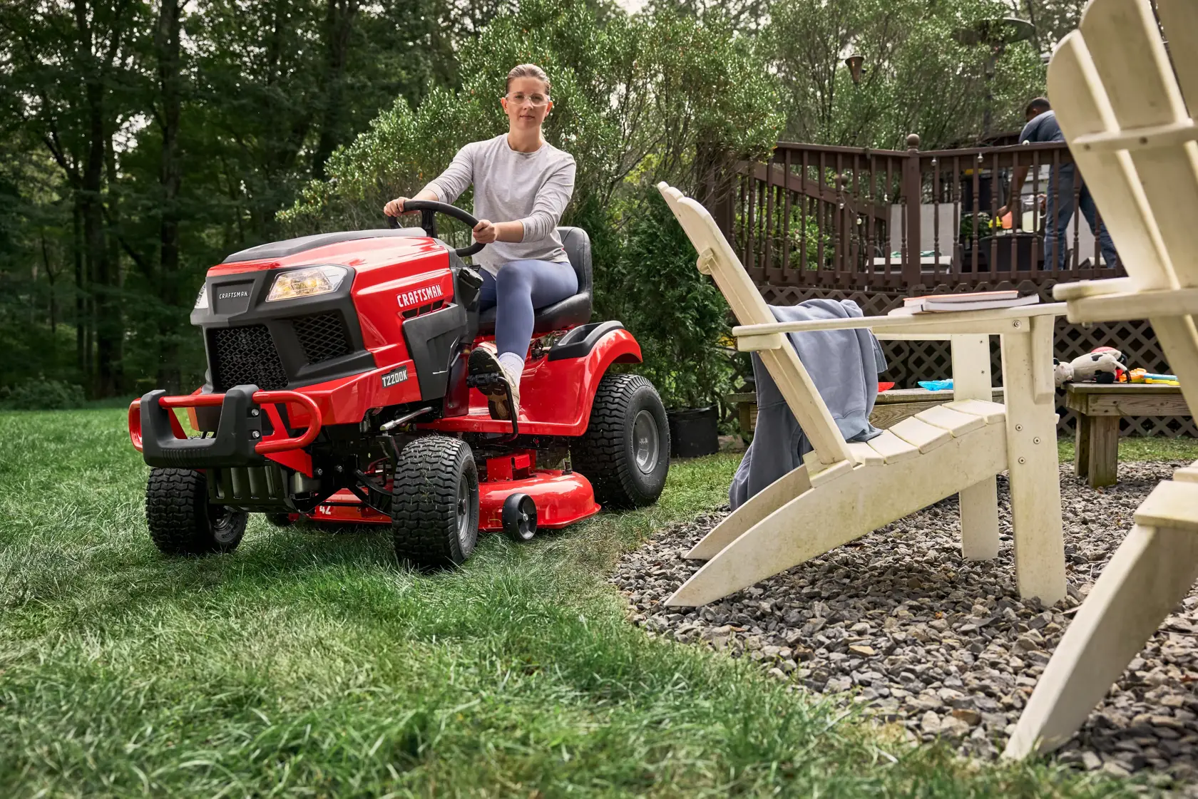 Owner riding the CRAFTSMAN T2200K past a backyard patio